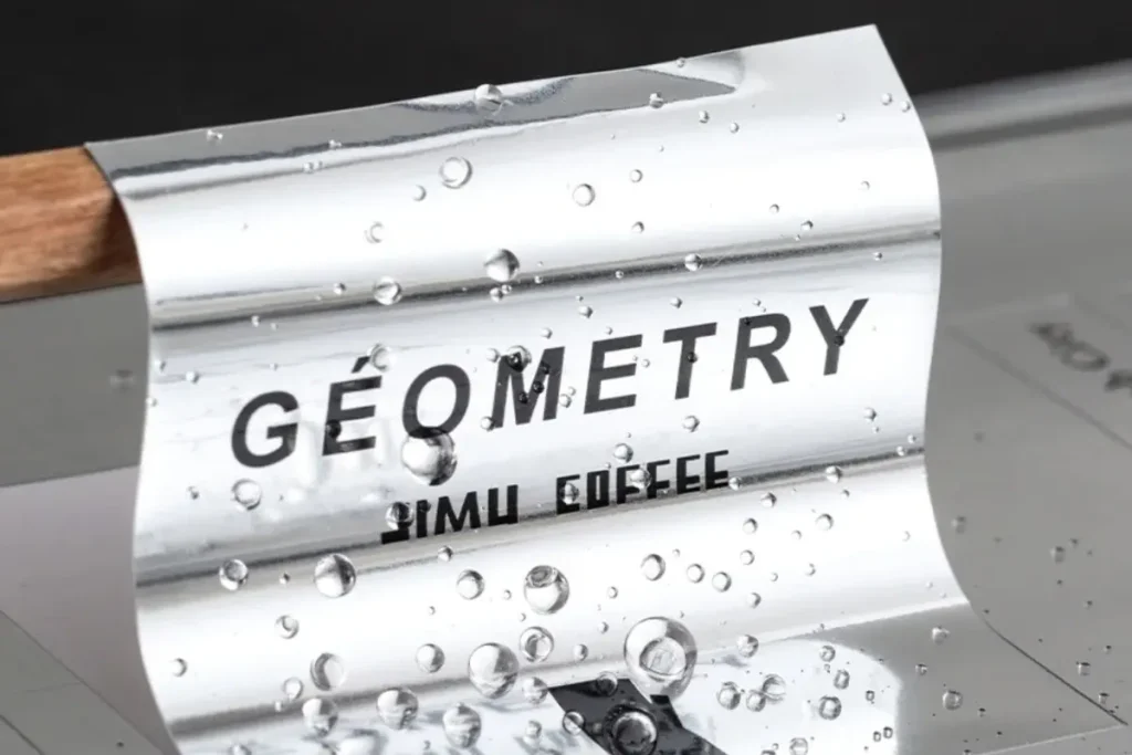 Waterproof bright metallic silver sticker with a reflective chrome finish, covered in water droplets to show its durability.